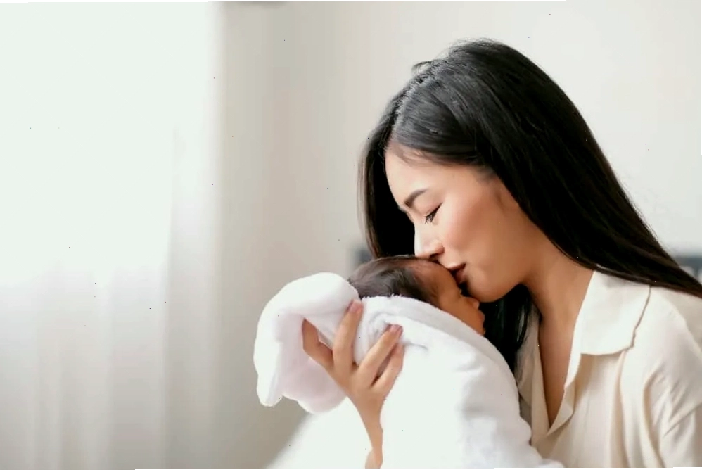Bé sơ sinh đang được mẹ vỗ ợ hơi sau khi bú để giảm nấc cụt