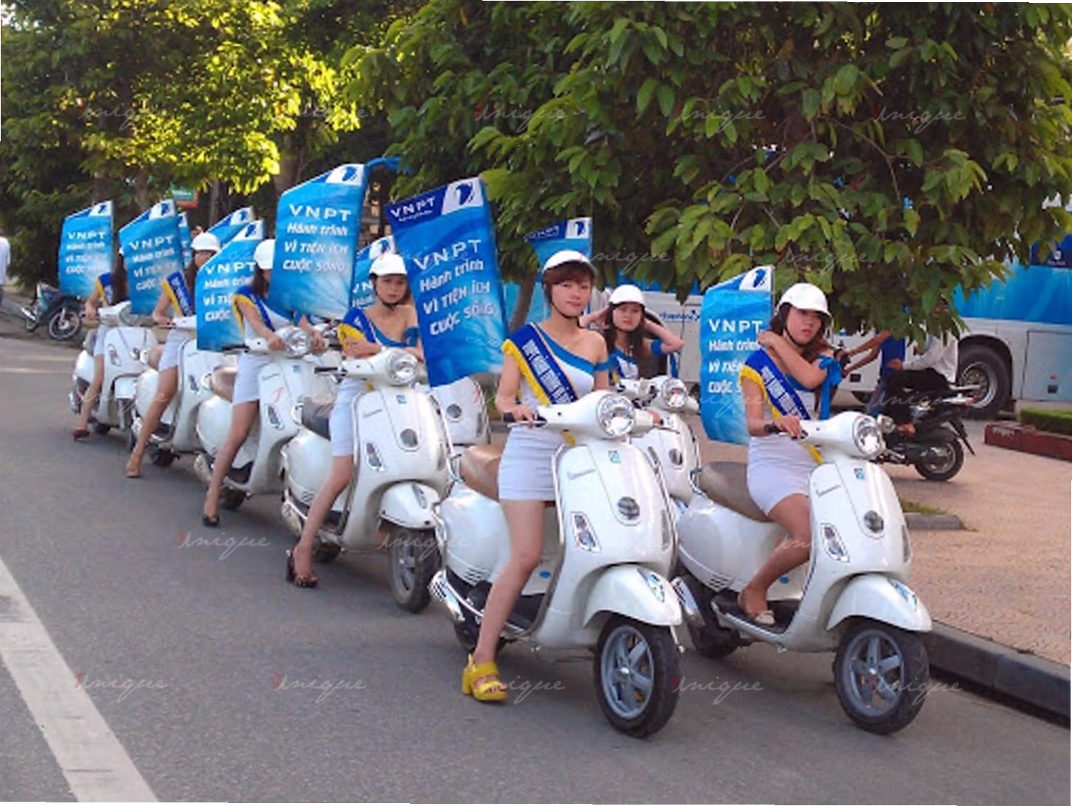 Nhân viên roadshow di chuyển bằng xe máy với trang phục và logo thương hiệu